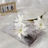 Nueva simulación de flores de 3 cabezas, pequeño lirio, fondo de auditorio de boda, mesa de hotel suave, flores falsas colocadas