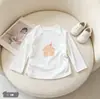 Nueva colección de primavera y otoño: Blusa elegante y linda de manga larga con estampado de dibujos animados para niñas, con un diseño coreano simple y versátil