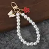 Chaveiro de pérolas estilo Chanel com pingente de flor, chaveiro anti-perda, capa de fone de ouvido, acessório para bolsa de celular