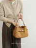Coleção Outono/Inverno 2026: Bolsa tote simples e minimalista feita de couro genuíno, com fecho de cadeado, design de mini bolsa balde e um estilo versátil adequado para carregar no ombro ou na mão, perfeita para o dia a dia.