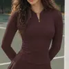 Mono de tenis de estilo europeo y americano más vendido, de manga larga con media cremallera en color marrón oscuro, para fitness al aire libre, con pantalones cortos de seguridad incorporados