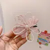 Dulce Atmósfera de Vacaciones en la Playa junto al Mar con Flores de Hibisco de Colores, Pasadores Bohemios de Plumeria y Accesorios Florales para el Cabello