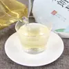 Té pu'er crudo de Yunnan de principios de primavera al por mayor Pastel de siete semillas de té de brotes tiernos de principios de primavera marrón punta de primavera 357g