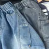 Roupas novas para crianças 2026, coleção de outono para meninos, calças estilo workwear com bolsos grandes, jeans do papai, jeans de perna curva, atacado