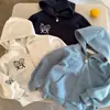 Ropa de abrigo para niños 2026, nueva colección de otoño: sudaderas unisex con capucha con un diseño de "ojos entrecerrados", con un patrón de figuras de palo y detalles bordados, con cremallera