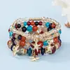 Pulseras multicapa al por mayor, juego de cuatro piezas de joyería con cuentas de artesanía en vidrio, juego de pulseras elásticas, accesorio de mano con soporte de flor de hierro