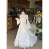 Suave y elegante, con un efecto de luz suave y difusa, presenta un estampado floral, adornos de mariposas, un dobladillo con volantes y un escote cuadrado de aspecto de hada.. Este vestido de manga larga es de la nueva colección otoño 2026