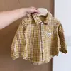 Conjunto de otoño moderno y elegante para niños: un conjunto de tres piezas que incluye un chaleco de dibujos animados, una camisa de cuadros y pantalones, perfecto para niños pequeños