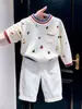 Suéter de punto de estilo coreano para niños, nuevo de otoño 2026, con estampado de dibujos animados, letras, bloques de color, y pantalones casuales blancos para niños