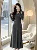 Elegante vestido negro de punto para mujer, diseñado para otoño e invierno, con cintura ajustada y silueta estilizada.