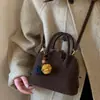 Bolsa de concha de nicho de alta gama para mujer 2025 Nuevo estilo coreano retro de un solo hombro bandolera pequeña bolsa de mensajero bolsa de boliche