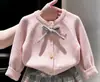 Conjunto de dos piezas para niña estilo coreano otoño e invierno 2026: suéter de punto rosa con lazo y falda plisada a cuadros para niños