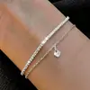 Pulsera en capas de cadena de clip con colgante de cruz minimalista transfronteriza europea y americana, una pulsera de estilo de lujo moderno y discreto para mujer