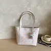 Bolso tote moderno y práctico de gran capacidad con un diseño de dibujos animados en relieve, un nuevo y elegante bolso de hombro y un bolso tipo cubo adecuado para estudiantes universitarios.