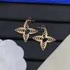 Pendientes de botón con letras y logo de marca de lujo europea y americana transfronteriza, versión de alta gama nueva, pendientes de trébol de cuatro hojas con aguja de plata para mujer, venta al por mayor