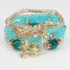 Pulseras multicapa al por mayor, juego de cuatro piezas de joyería con cuentas de artesanía en vidrio, juego de pulseras elásticas, accesorio de mano con soporte de flor de hierro