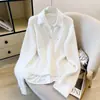 Moda coreana para mulheres: camisa com design de outono sobreposta a um suéter de tricô cinza