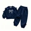 Conjunto Elegante para Niña para Otoño e Invierno 2026 Nuevo Conjunto de Dos Piezas para Bebé: Sudadera de Manga Larga con Lazo y Pantalones Casuales a Rayas