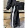 Tendência de moda outonal masculina: calças estilosas, com blocos de cor, de cordão, de perna reta; estilos masculinos e juvenis; calça pantalona de três listras, inspirada em faculdade
