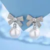Brincos estilo coreano, doces e fofos em formato de laço, com delicados detalhes em zircônia cúbica e pérolas artificiais, um design simples e versátil que realça seu visual geral, disponíveis para sourcing internacional