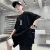 Camiseta de manga corta para niño, nuevo estilo de verano con bolsillos laterales y letras en la parte delantera y trasera, estilo urbano genial para niños mayores
