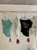 Wgwe9135 Ropa de Mujer Guangzhou Shisanxing Nuevo Estilo 2026 Top Camiseta de Manga Corta con Diseño Estampado de Hombro Descubierto y Cuello Diagonal Verano