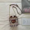 Bolso Cilíndrico con Lazo de Tablero de Ajedrez Fresco 2026 Nuevo Estilo Bolso Cruzado de Cadena Femenino Bolso de Hombro Casual Versátil