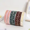 Serie Navideña Cinta de Terciopelo Estampada en Oro de 2.5 cm para Decoración Festiva, Envoltura de Regalos y Creación de Lazos con Cinta de Terciopelo