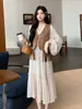 Roupas de maternidade para outono e inverno: um conjunto de duas peças apresentando um colete com franjas combinado com um vestido, com mangas tipo lanterna estilo francês para um visual emagrecedor e retrô, perfeito para usar como camada externa