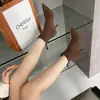 Botas de tornozelo minimalistas na cor chá com leite para mulheres, com efeito emagrecedor, saltos finos, material elástico e acabamento fosco estilo coreano.. Estas são as novas botas de salto alto da coleção outono 2026