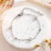 Diseño nicho de alta gama lujo ligero exquisito pulsera de acero de titanio con diamantes pequeños viento frío simple amigas joyería al por mayor