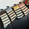 Tão coreano! O esquema de cores azul e marrom + design listrado é muito adequado para o outono e inverno! Meias de cano médio folgadas com listras coloridas e costura dupla
