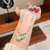 Collar Original de Moda Versátil Colorido de Esmalte Trébol de Cuatro Hojas Calabaza con un Toque de Lujo Ligero y de Alta Gama, Cadena para Suéter para Mujer