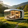 Casa cápsula espacial inteligente moderna e minimalista com iluminação completa e grandes janelas panorâmicas do chão ao teto para férias no campo, cabana pré-fabricada