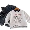 Camiseta de algodón puro para niños, modelo primavera y otoño 2026 para bebés y niños pequeños, top de dibujos animados graffiti estilo ins, camiseta interior de manga larga para niños