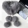 Foto real de un pañuelo con pompón de piel sintética de zorro, estilo largo con flecos y pompones, elegante y versátil, adecuado como cuello de pelo o calentador de cuello.
