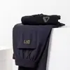 Calças casuais versáteis para homens, com forro de fleece, para o outono/inverno de 2026, cintura elástica, perna reta, corte solto, de fronteira.