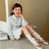 Conjunto de tres piezas para niña con cárdigan de cuello ribeteado de encaje y falda corta, nuevo estilo de verano para niños mayores, con camiseta y falda de rayas con bloques de color.