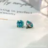 Liga de titânio F136 com cravação em garra de fundo redondo e detalhes verde menta, brincos de tarraxa Paraíba, rosca interna de titânio G23, argolas de lábio com zircônia cúbica