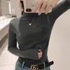 Camiseta base de punto de lana gris de alta gama y a la moda para mujer, jersey interior de cuello medio estilo europeo, top elegante de cuello medio