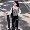 Conjunto moderno y casual para niños mayores: un chaleco lindo con tema de oso, una camisa con cuello de muñeca y pantalones anchos versátiles de retazos a cuadros