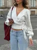 Top de punto ajustado con cuello en V cruzado estilo europeo y americano para otoño e invierno, top corto elegante irregular con corbata para mujer al por mayor
