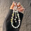 Elegante correa de cristal para teléfono móvil con forma de flor de ciruelo, con lazo tachonado de diamantes de imitación y borla, accesorio corto para bolso de muñeca