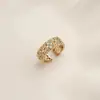 Anillo retro floral en tono café dorado, una pieza lujosa y única con un aire de alta gama, diseñado para apilar, con un borde de encaje, y perfecto para el dedo índice, ofreciendo un estilo moderno e individual