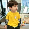 Camiseta de manga comprida 100% algodão para meninos, nova camiseta básica com estampa de desenho animado para primavera e outono de 2026, top listrado estiloso para crianças mais velhas