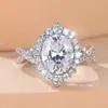 Anel de Noivado Feminino Twist Band com Coroa Dupla Cravejada de Diamantes, Pedra Principal Grande Oval Moissanite, Fonte de Suprimento