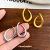 Pendientes de anillo retorcido minimalistas europeos y americanos de aguja plateada, pendientes de lujo ligero de alta gama, pendientes de diseño único de nicho al por mayor