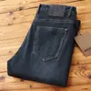 La fuerte combinación de Wang Qian de nuevos jeans casuales rectos de alta gama elásticos para hombre de otoño e invierno, engrosados y cepillados