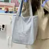 Bolsa de Lona Listrada Feminina Outono 2025 Nova Tendência Estilo Preppy Coreano Bolsa Tote com Letra Casual Grande Capacidade A39