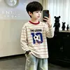 Camiseta infantil listrada de manga longa estilo coreano, novo modelo da primavera de 2026, top interno para meninos, camiseta básica 100% algodão para crianças mais velhas